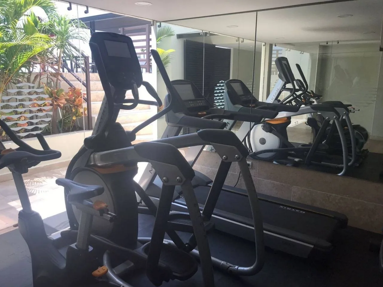 Gym with cardio equipment and a mirrored wall