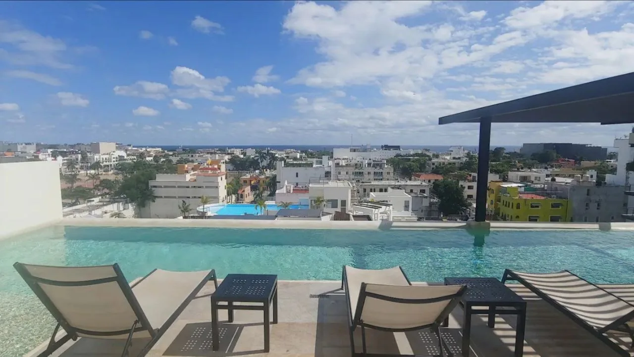 Rooftop pool with sun loungers and views over Playa del Carmen